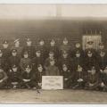 P.O.W. soldiers & sign “Artists & Staff 1918 Rennbahn Empire” William McLeish in front row. WWI
